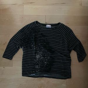 Silver, black, and grey splattered design on grey/ black striped quarter sleeve.